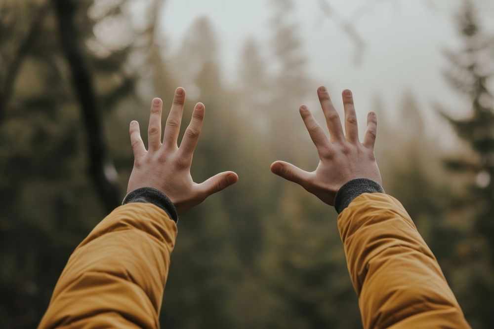 Extreme close up of person raising hands finger tranquility landscape.