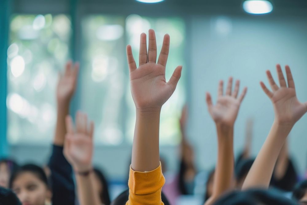 Extreme close up of students raising hands gesturing education learning.