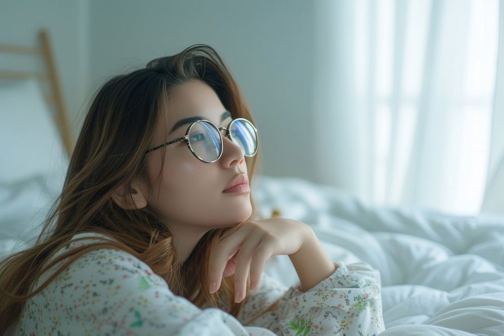 Woman thinking glasses portrait bedroom.