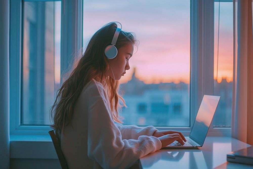 Woman typing on laptop headphones computer window.