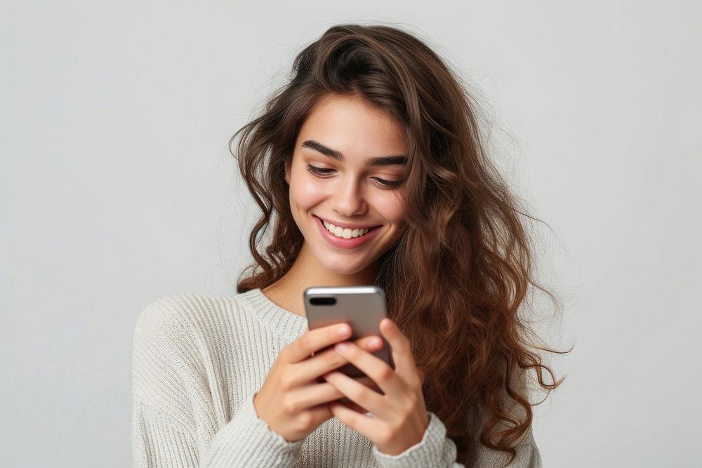An attractive young woman using a smartphone adult smile photo.