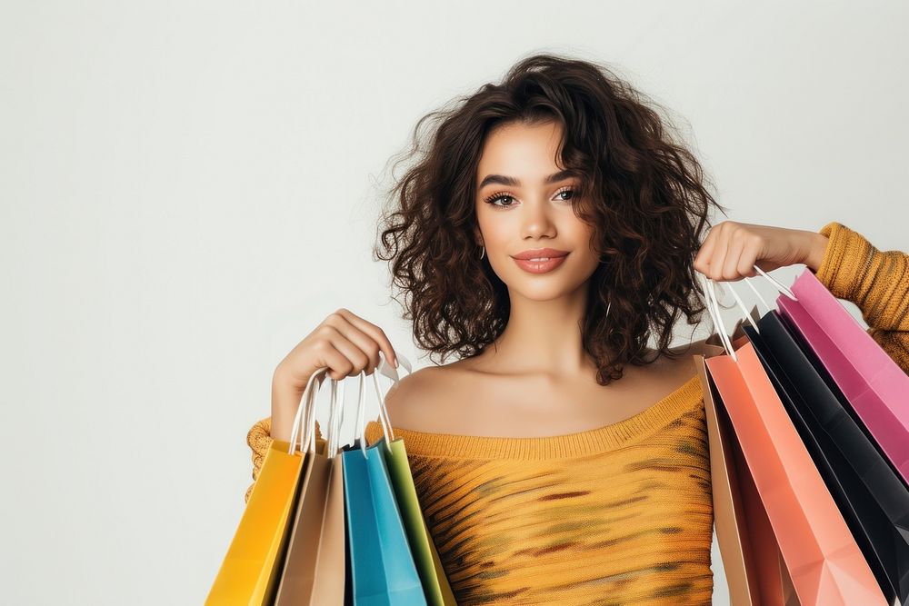 Portrait of an attractive young woman posing and holding up shopping bags portrait adult white background.