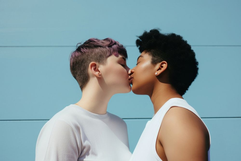 Lesbian couple kissing outdoors day affectionate.