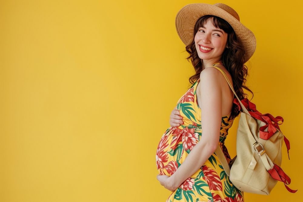Pregnant woman posing with toatbag vacation handbag travel.