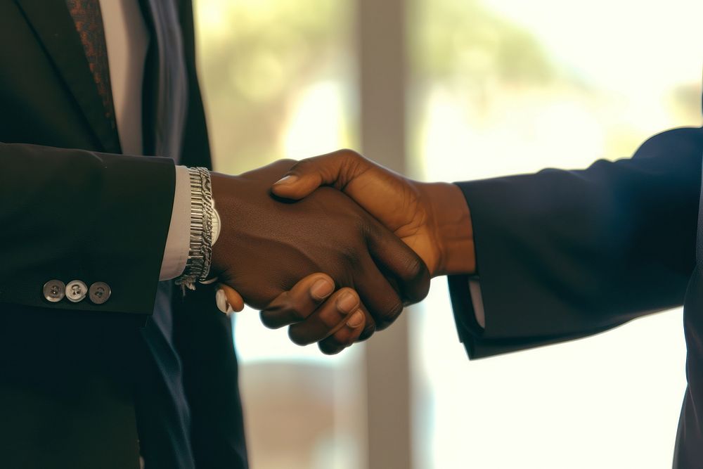 Two black man business men are hand shaking handshake agreement greeting.