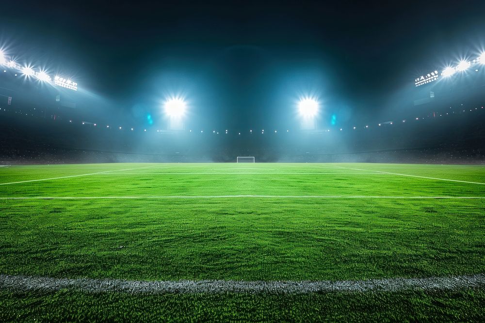 Green football feild with 2 open spotlights outdoors stadium night.
