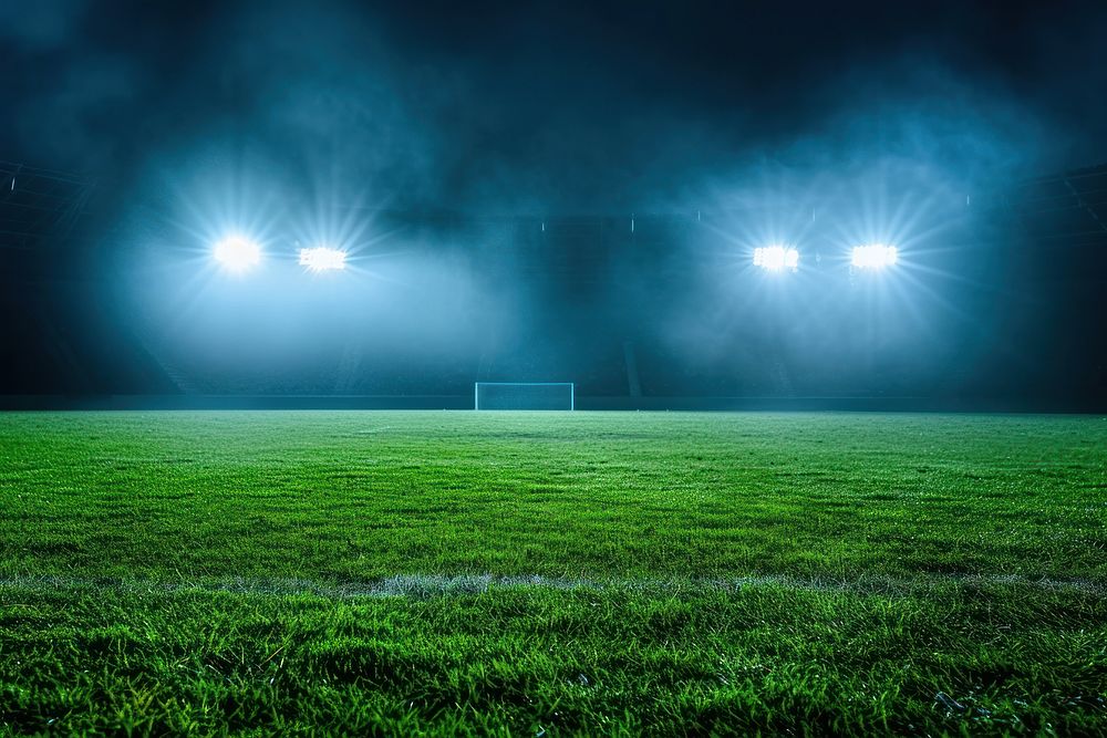 Green football feild with 2 open spotlights outdoors stadium nature.