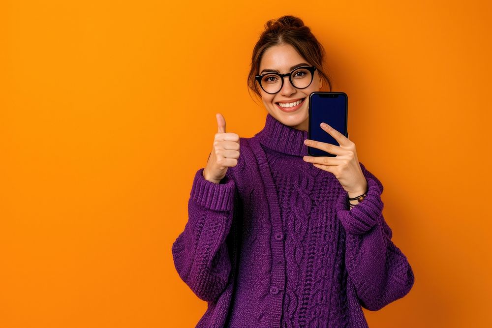 Woman showing phone screen sweater smile photo.