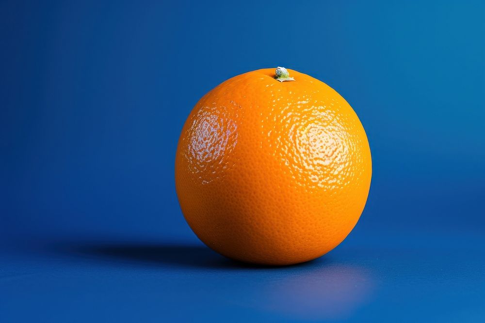 An orange in the middle on blue background grapefruit plant food.