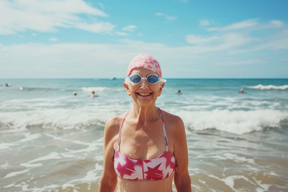Senior woman standing at seawaves sea wearing swimming hat swimwear outdoors nature.