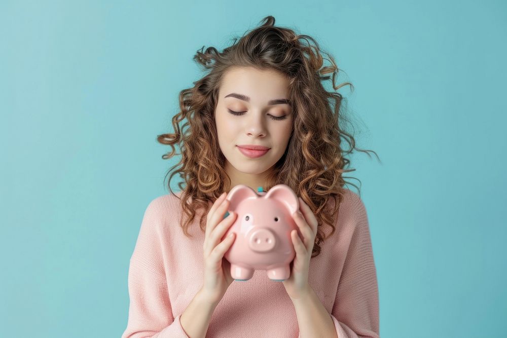 Woman who puts coin in piggy bank portrait savings holding.