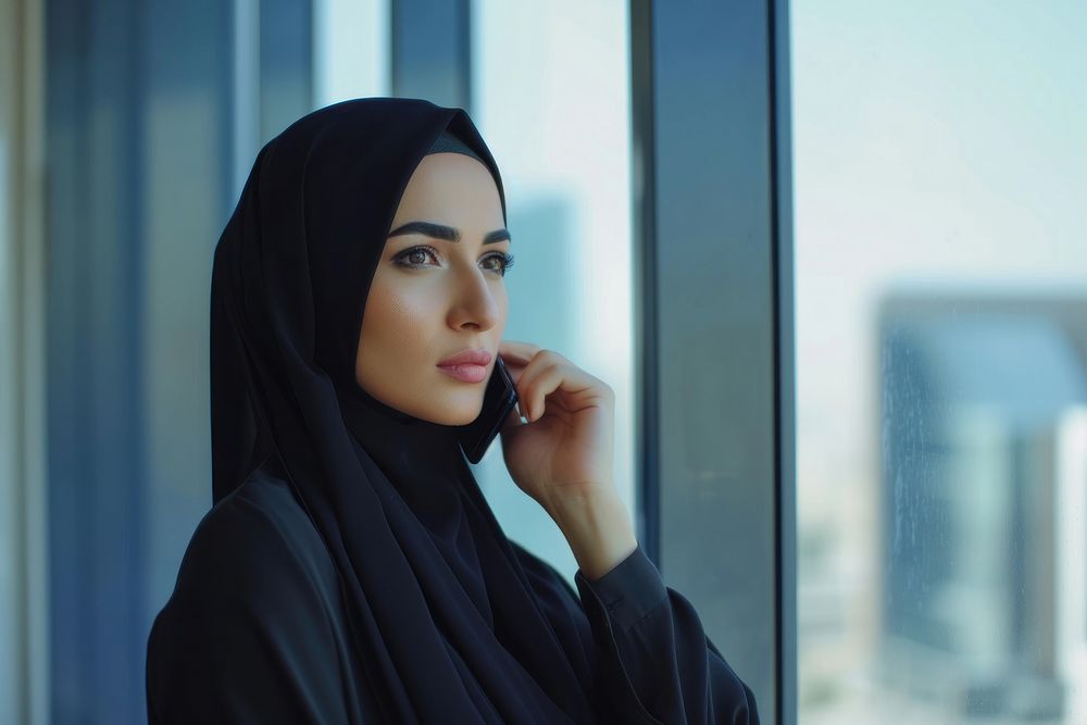Middle eastern woman headscarf window office.