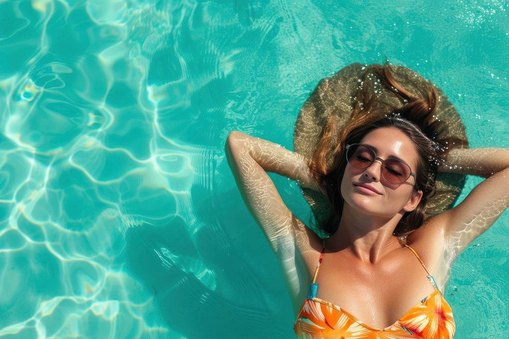 Woman lying on the back in the blue sea water summer sunglasses swimwear.