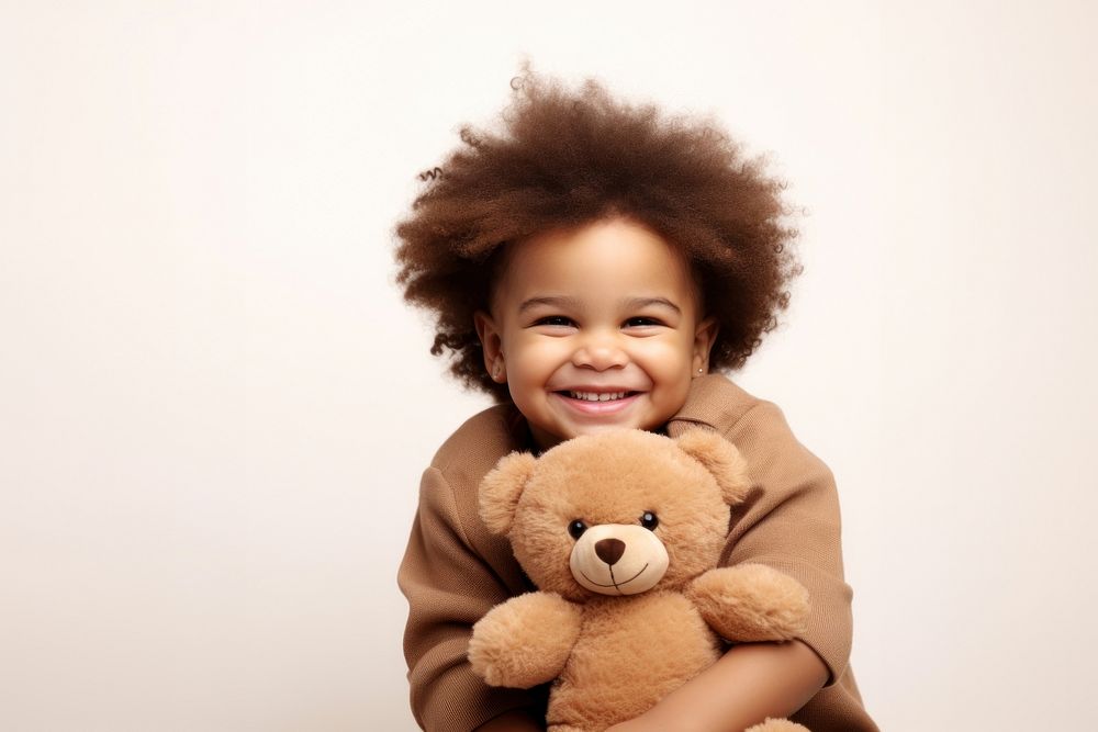 Little black boy with teddy bear portrait laughing child.