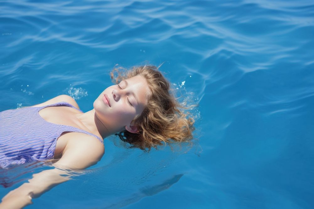 Girl lying on the back in the blue sea water summer swimming swimwear.