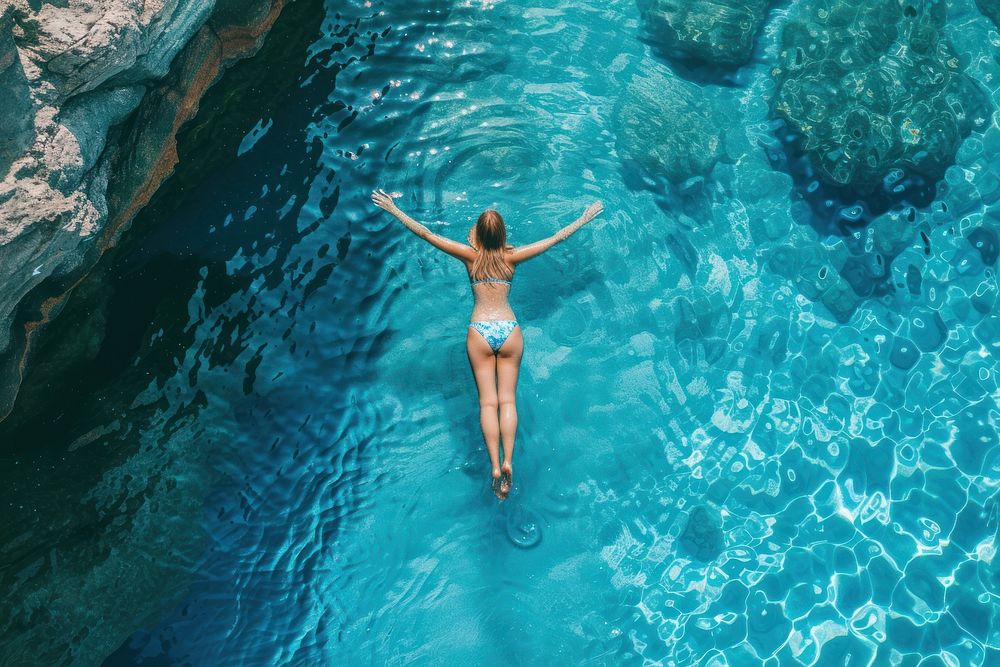 Girl wearing lying on the back in the blue sea water vacation swimming swimwear.