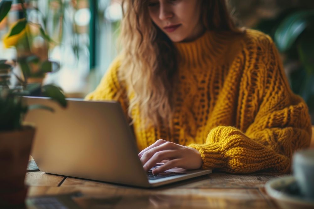 Woman using a laptop or tablet computer sweater yellow.