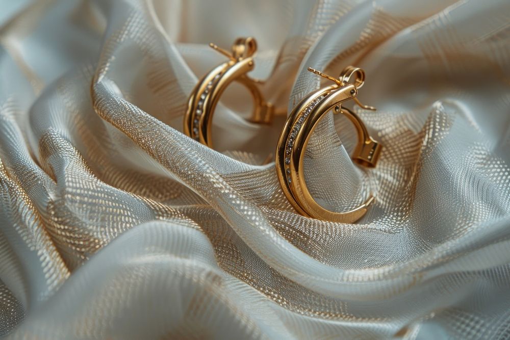 Golden earrings jewelry textile white.