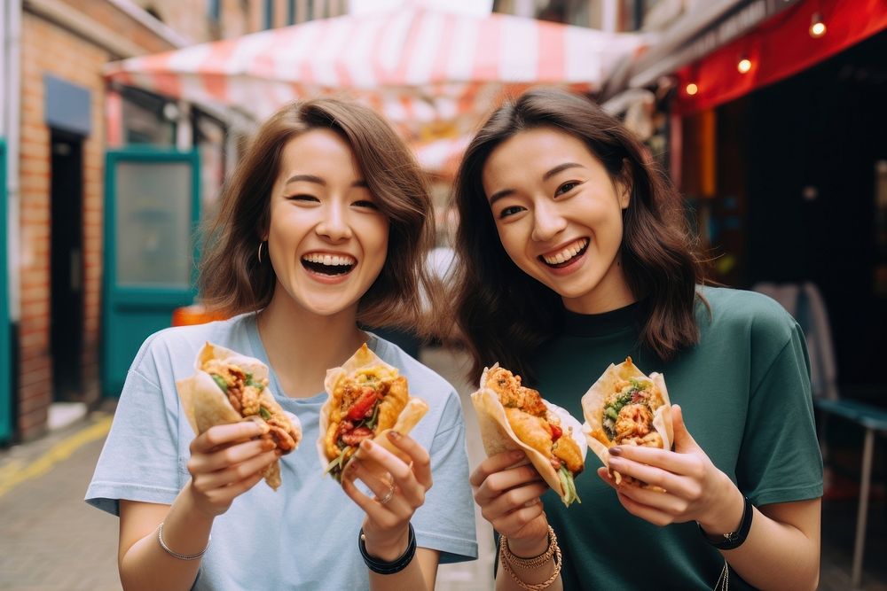 Two vloggers film a video with their street food sandwich adult togetherness.
