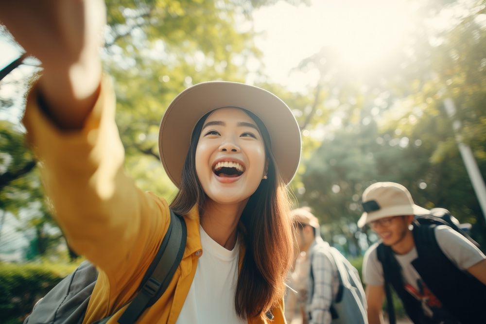 A young Asian woman taking selfie at the park on morning using smartphones laughing travel adult.