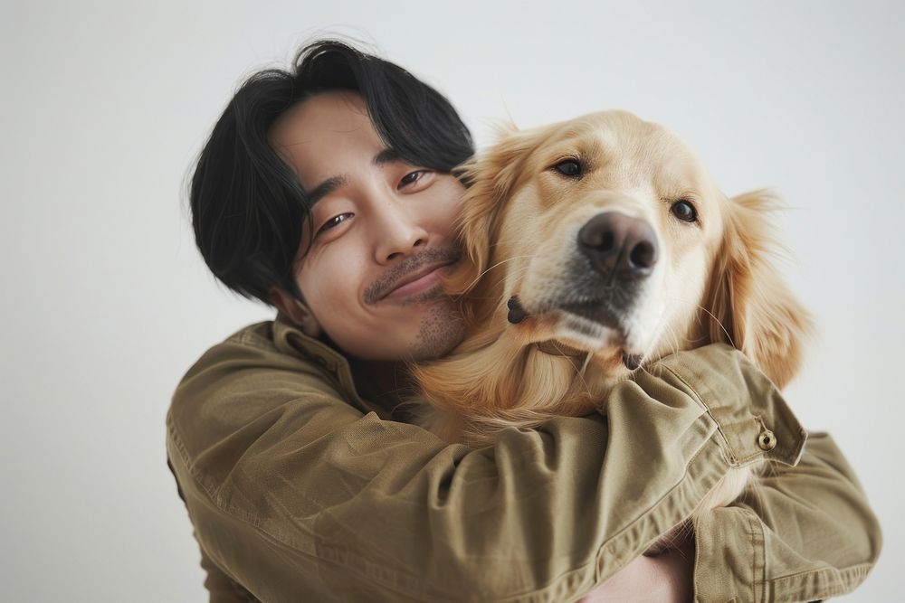 East asian man hugging Golden Retriever retriever portrait animal.
