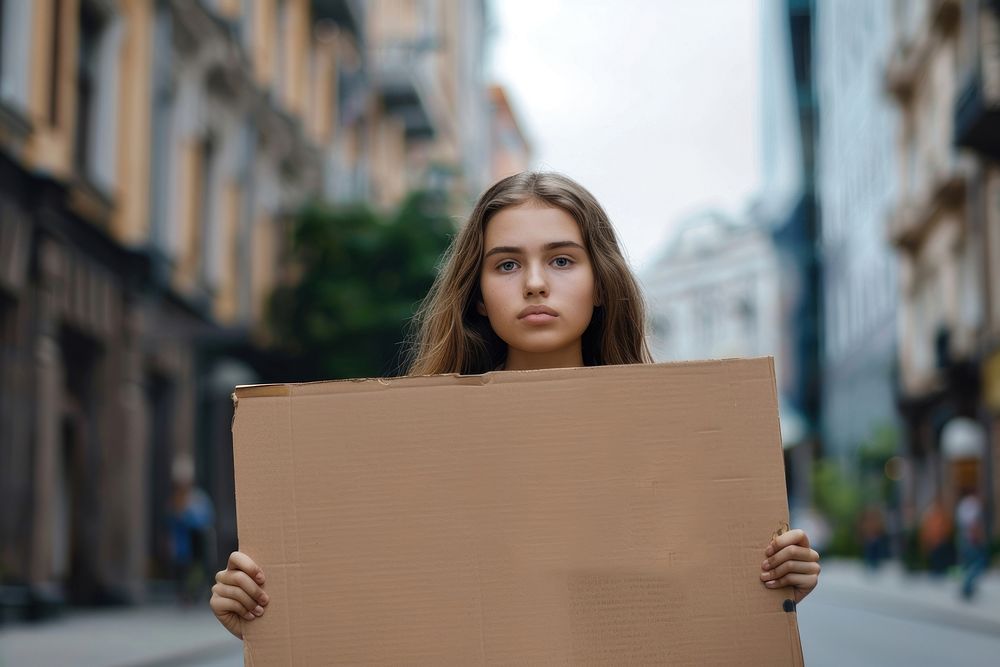 Woman holding placard contemplation neighbourhood homelessness.