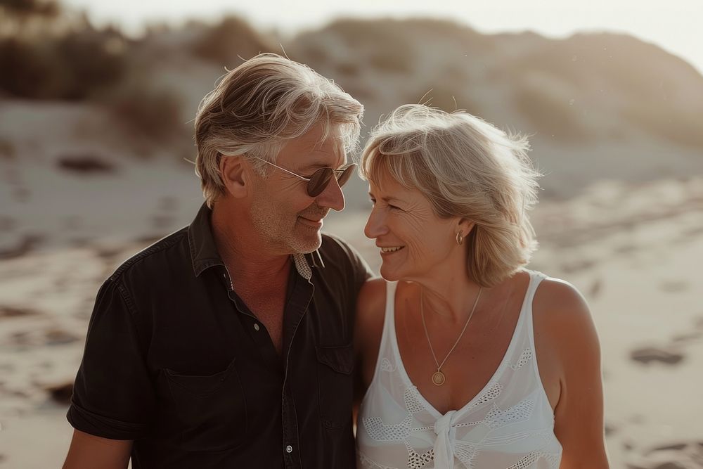 Middle-aged couple walking together beach portrait outdoors.