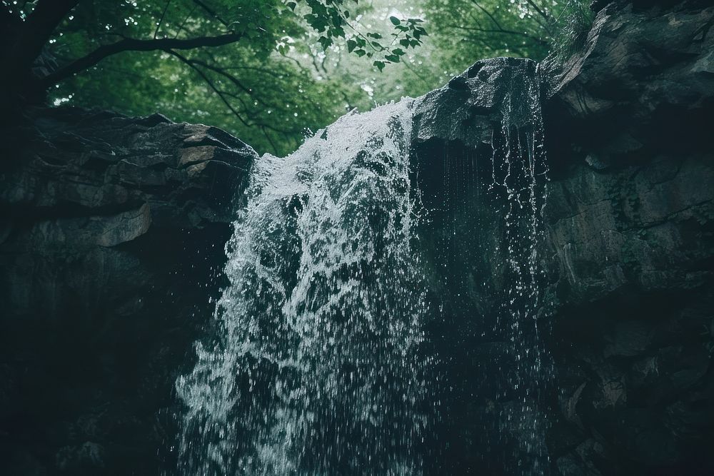 A waterfall coming from the top of a cave outdoors nature forest.