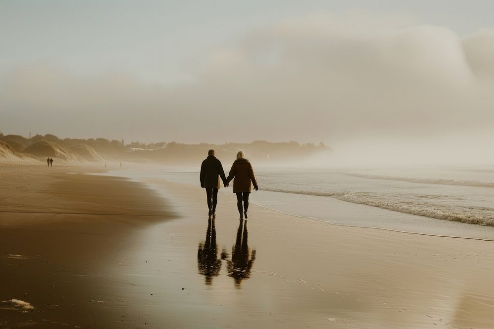 Older couple walking together beach outdoors nature.