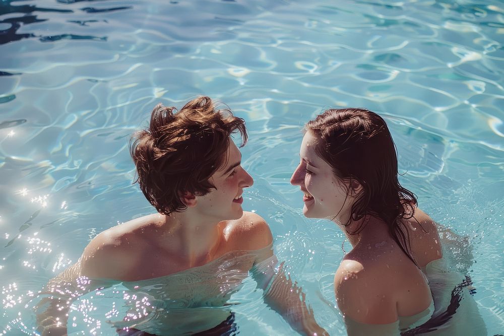 Boyfriend and girlfriend enjoying together in swimming pool swimwear outdoors portrait.