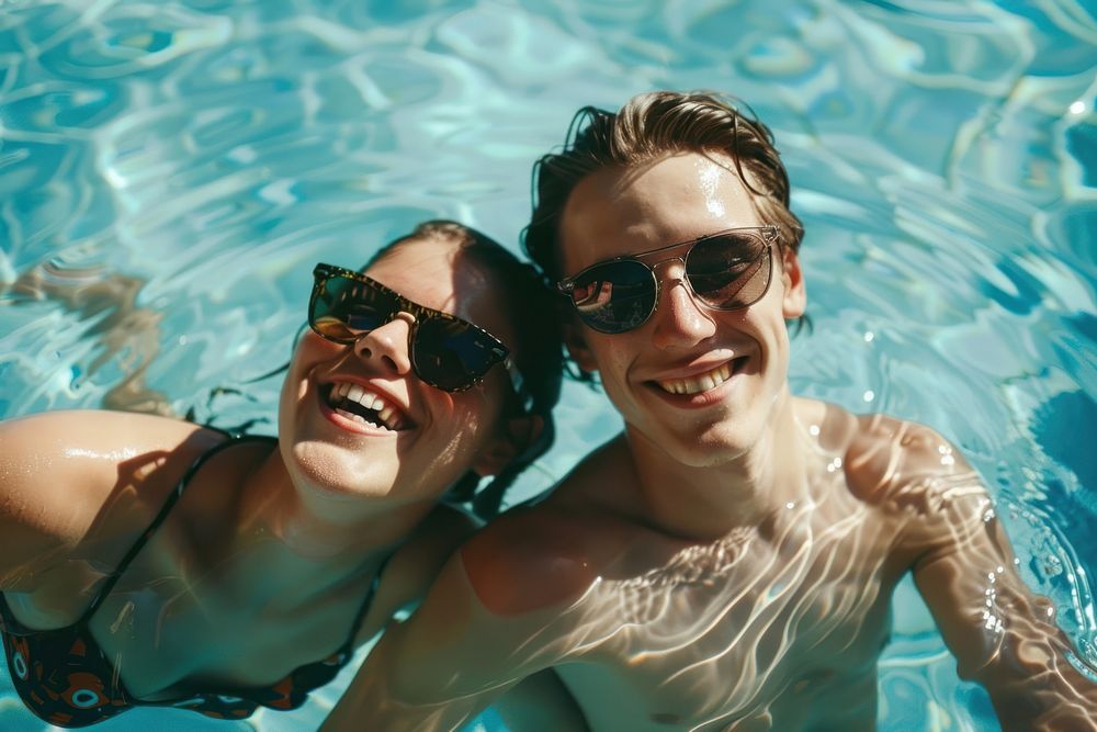 Boyfriend and girlfriend enjoying together in swimming pool sunglasses swimwear portrait.