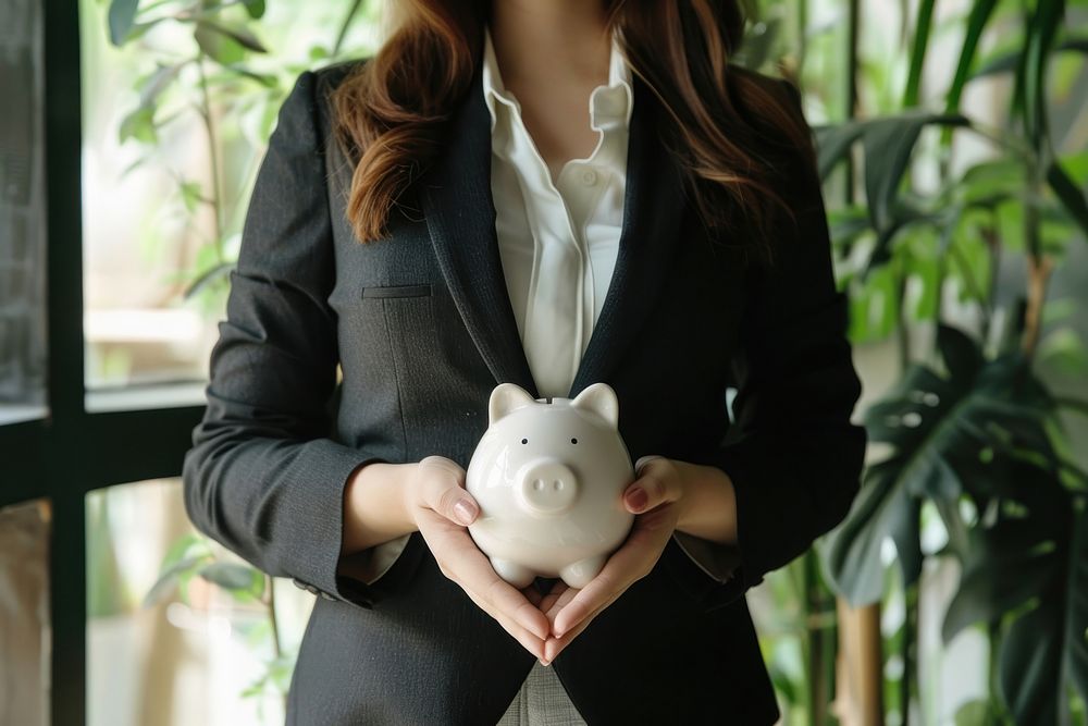 Business women holding piggy bank representation investment currency.