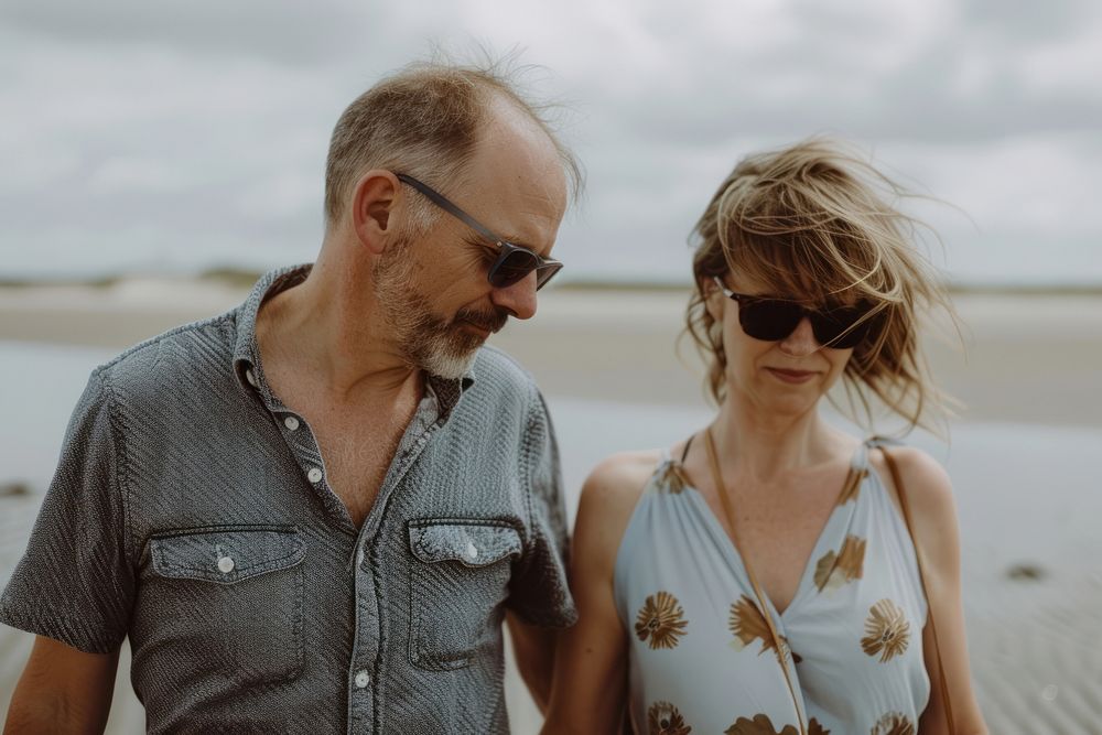 Middle-aged couple walking together sunglasses portrait outdoors.