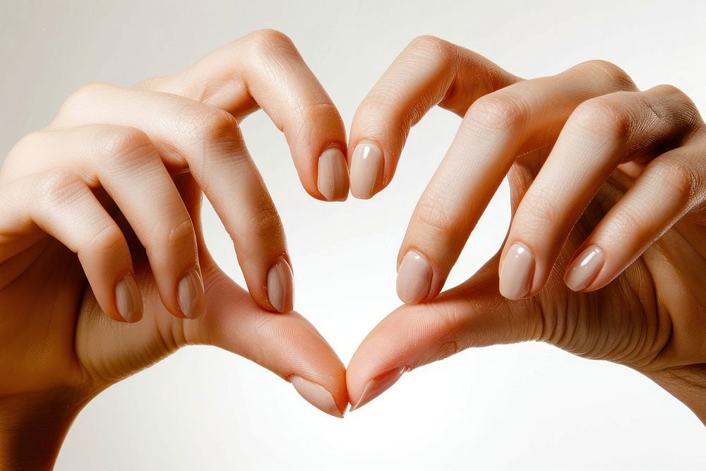 Two hands that are making a heart shape nail fingernail cosmetics.