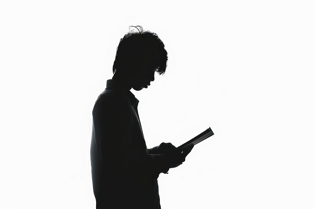 A book silhouette backlighting reading.