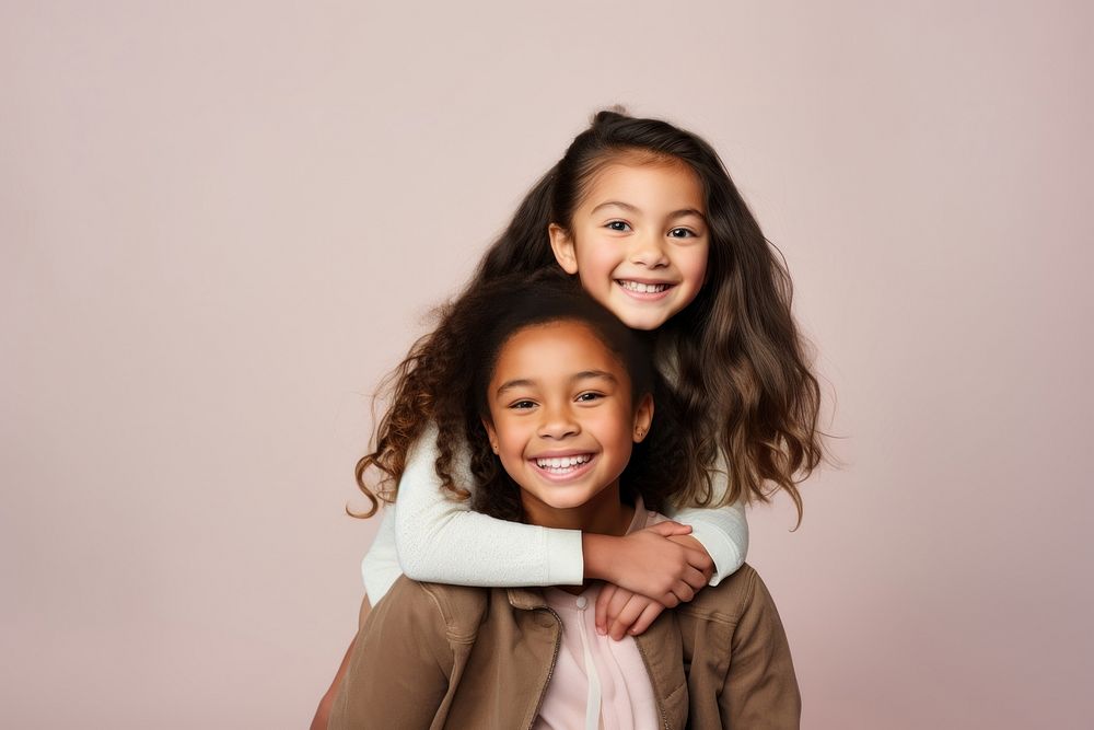 Mixed race girl piggybacking her sister portrait family child.