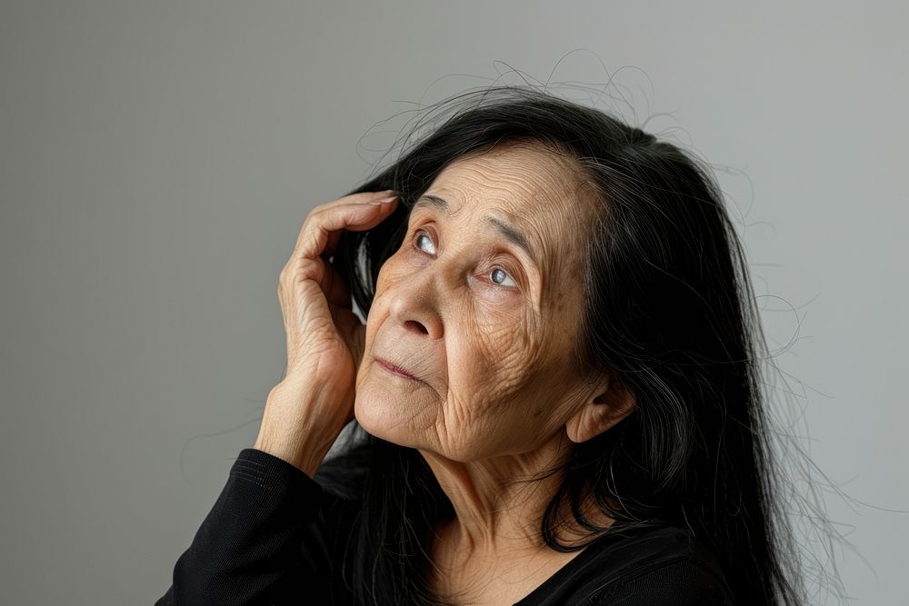 Hispanic old woman with black hime hair portrait photography worried.