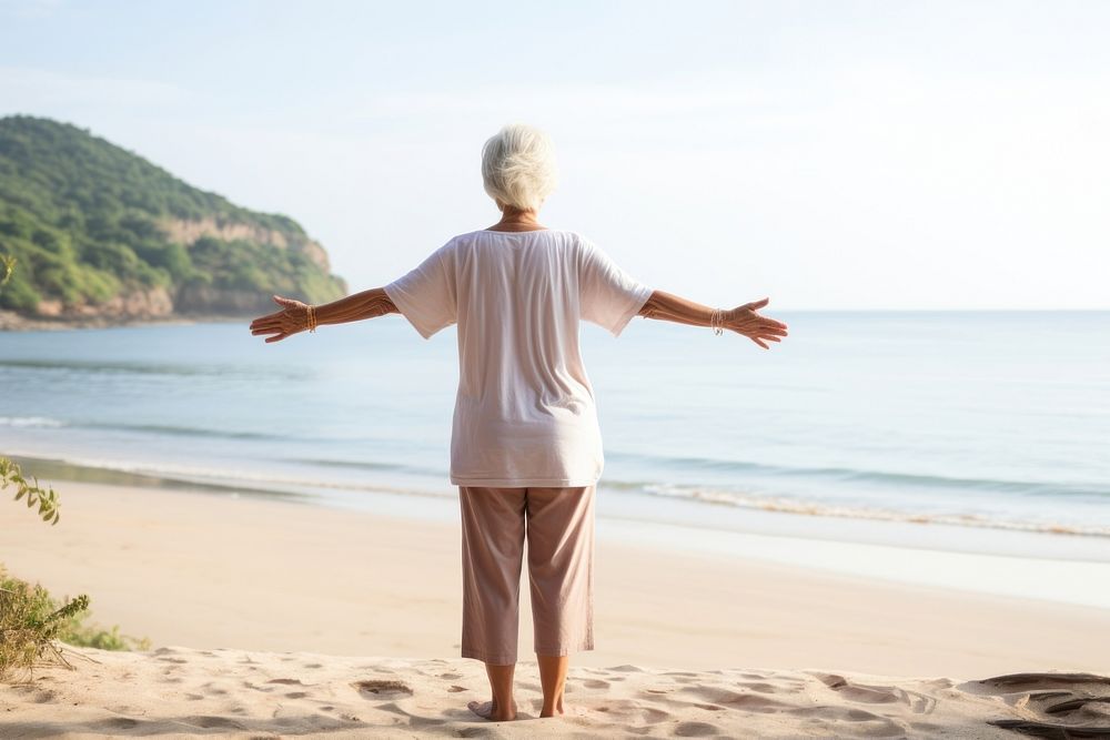 Elderly woman doing yoga standing beach adult.