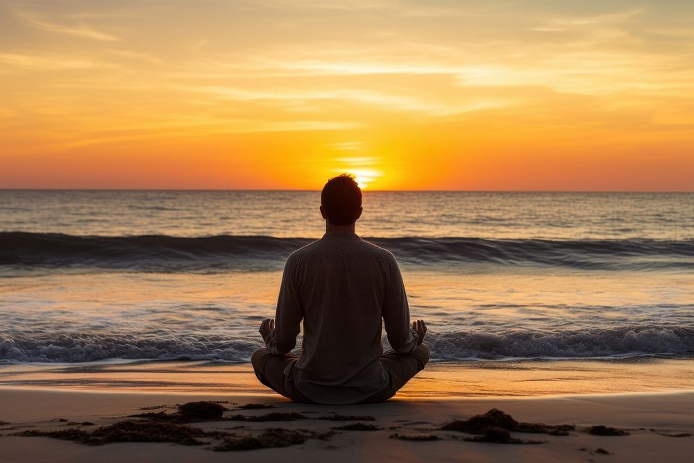 Middle age man doing yoga outdoors sitting sunset.