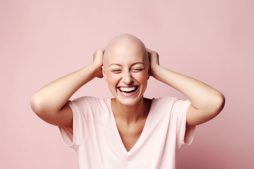 Bald woman touching shaved head laughing adult smile.