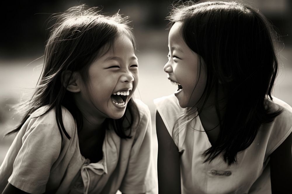 Thai girl laughing with her friend child adult togetherness.