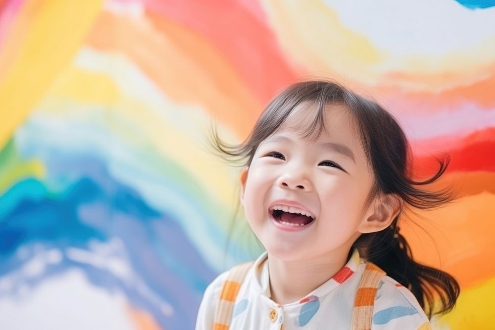 Asian little girl is painting the colorful laughing smile child.