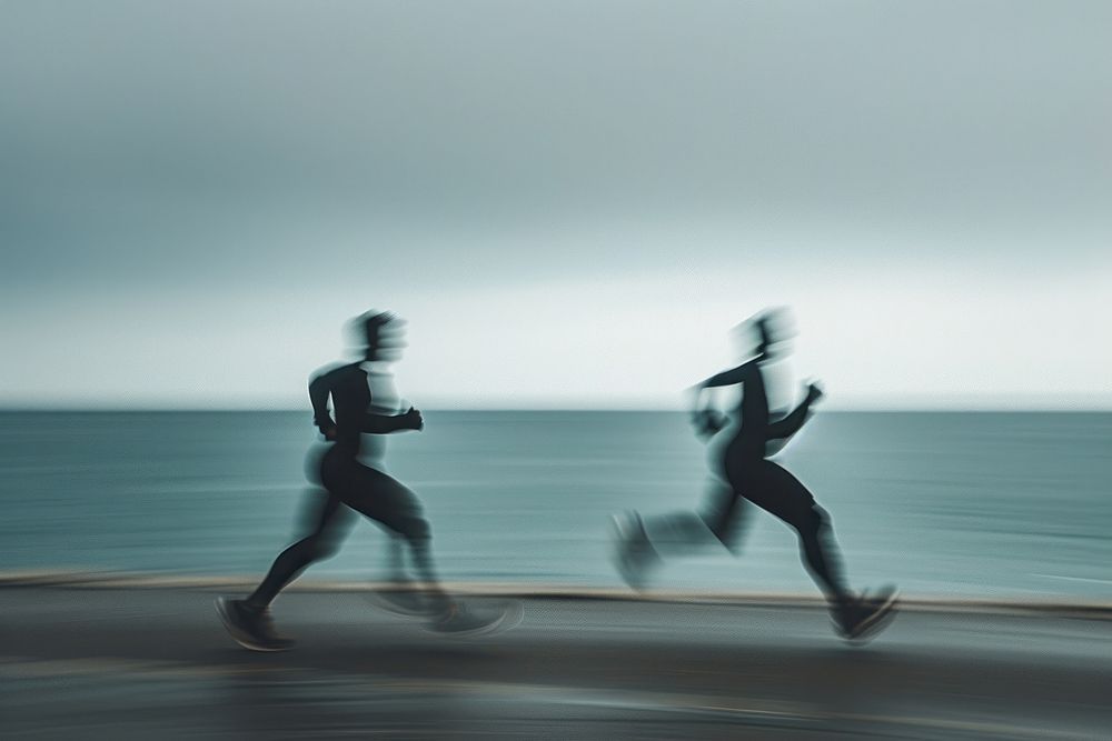 Male athletes running on overcast day jogging motion exercising.