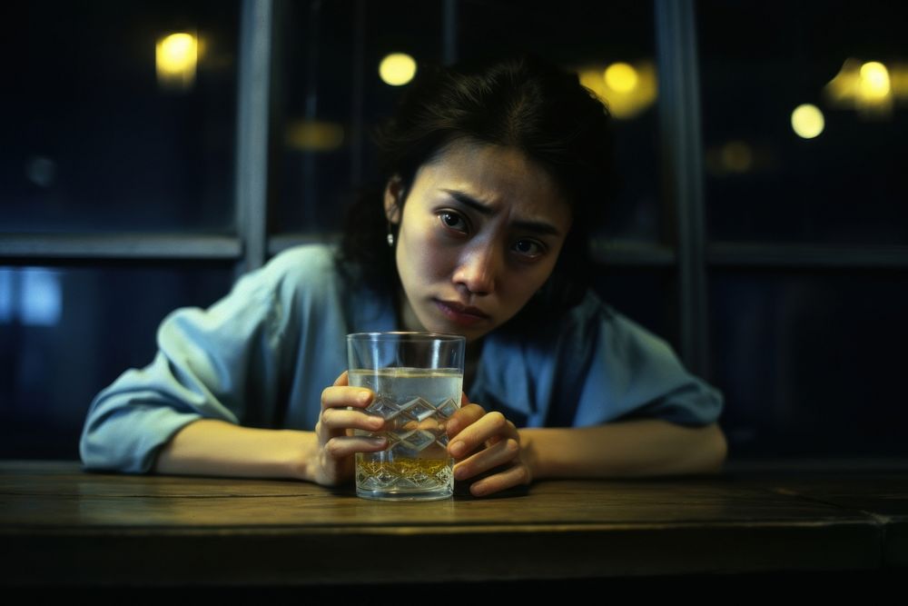 Young female crying in the bar drinking glass table.
