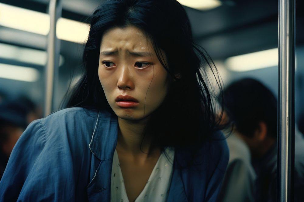 Young Loas female crying in the Train worried adult sad.