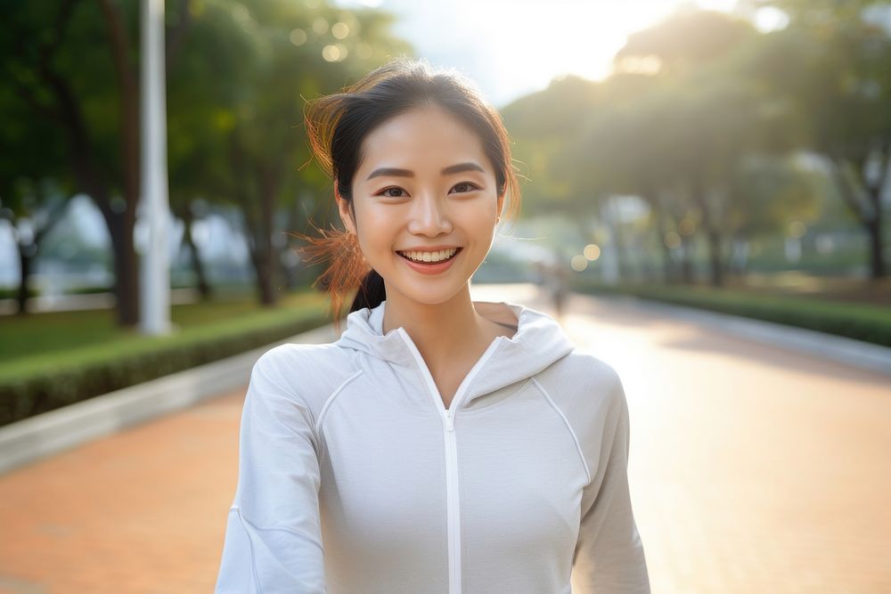 An asian athlete taking selfie while jogging in public park smile adult architecture.