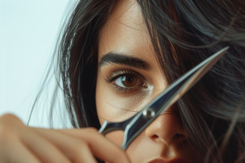 A long hair woman holding scissors to cut her hair adult nose hairstyle.