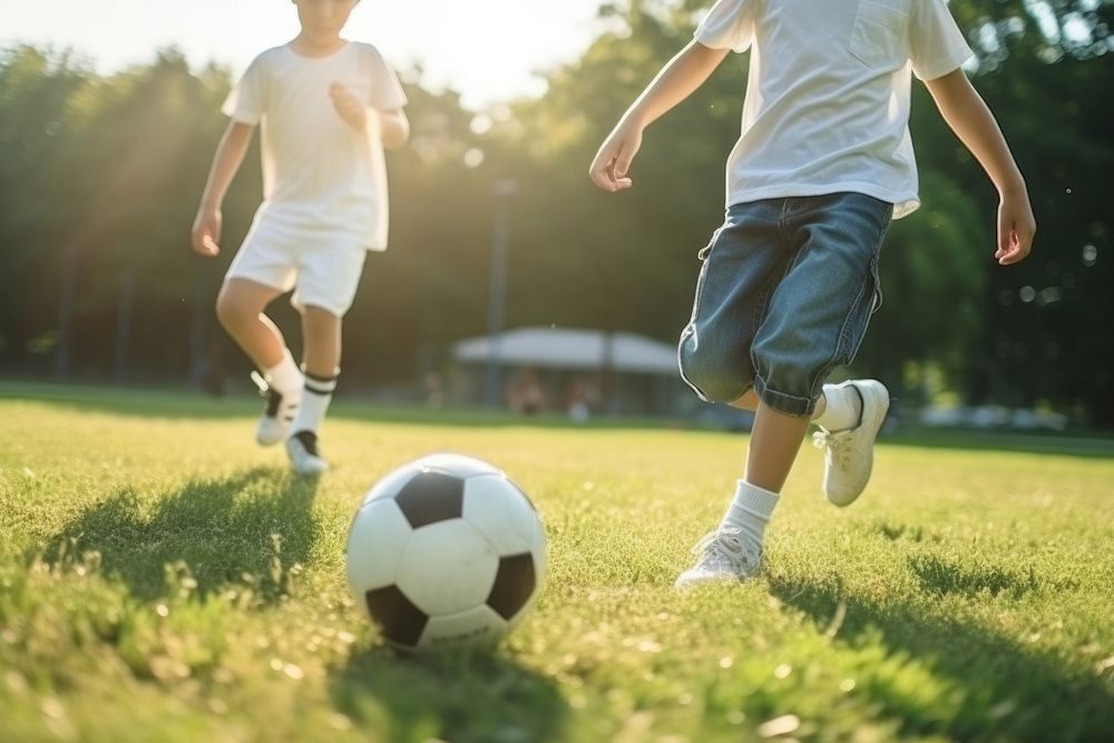 A boy kicks a football outdoors sports soccer.
