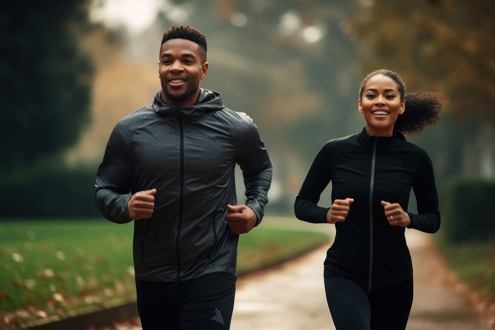Black woman and man in sport wear running in park outdoors jogging sports.