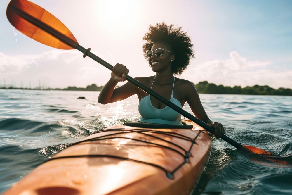 Black woman doing kayak recreation kayaking outdoors.
